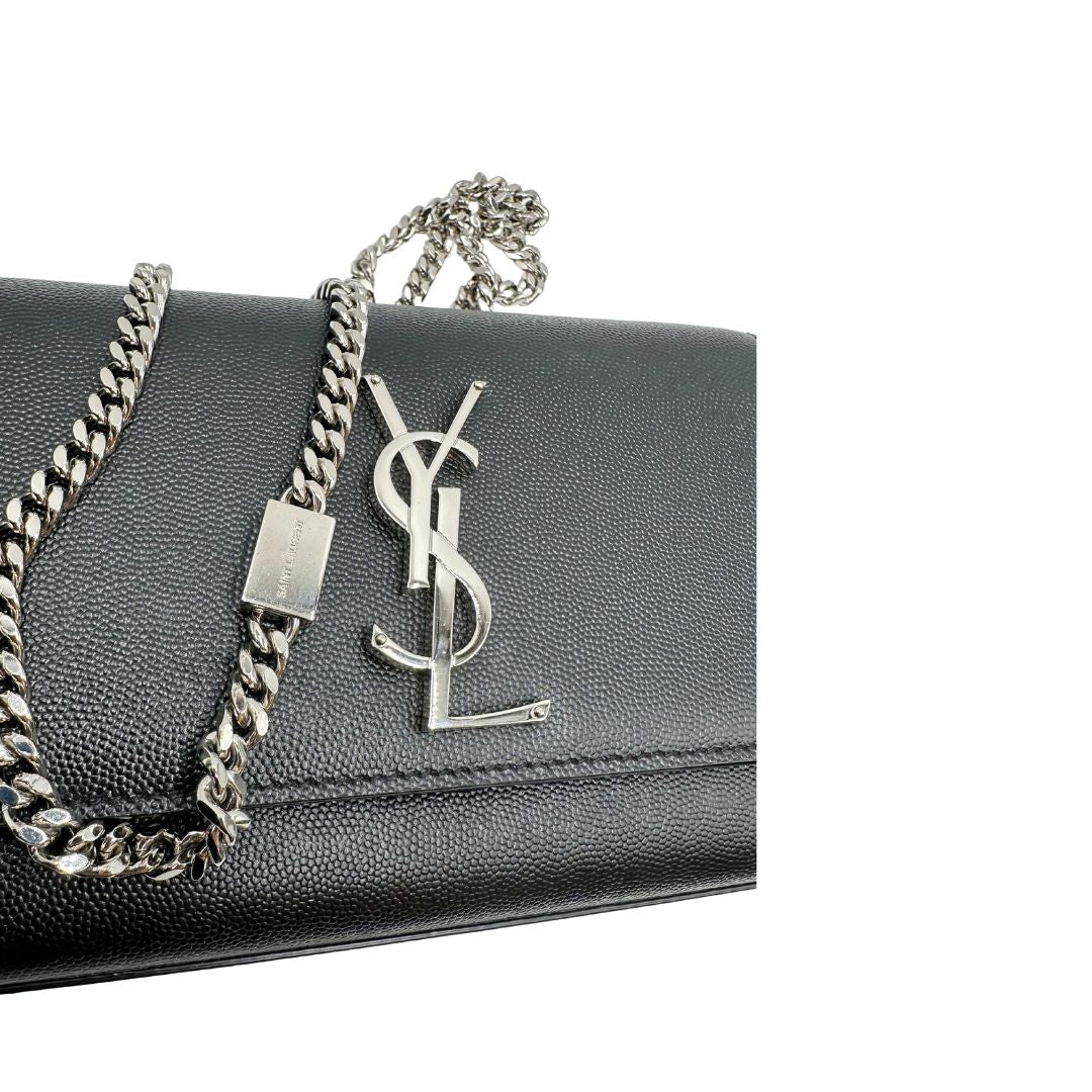 Wallet Kate On Chain Saint Laurent in pelle martellata nera con parti metalliche argentate, munita di una tracolla in catena . Indossabile a tracolla oppure a spalla. Completa di dustbag. Originale, usata, di lusso, in ottime condizioni.