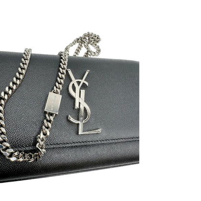 Wallet Kate On Chain Saint Laurent in pelle martellata nera con parti metalliche argentate, munita di una tracolla in catena . Indossabile a tracolla oppure a spalla. Completa di dustbag. Originale, usata, di lusso, in ottime condizioni.