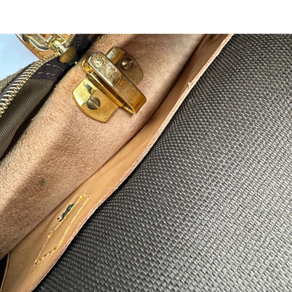 Porta abiti in canvas marrone monogram con finiture in vacchetta naturale e parti metalliche dorate; munita di due manici stondati. Completa di due lucchetto, chiavi, tag porta address e una dustbag. Originale, usata, di lusso, in ottime condizioni.