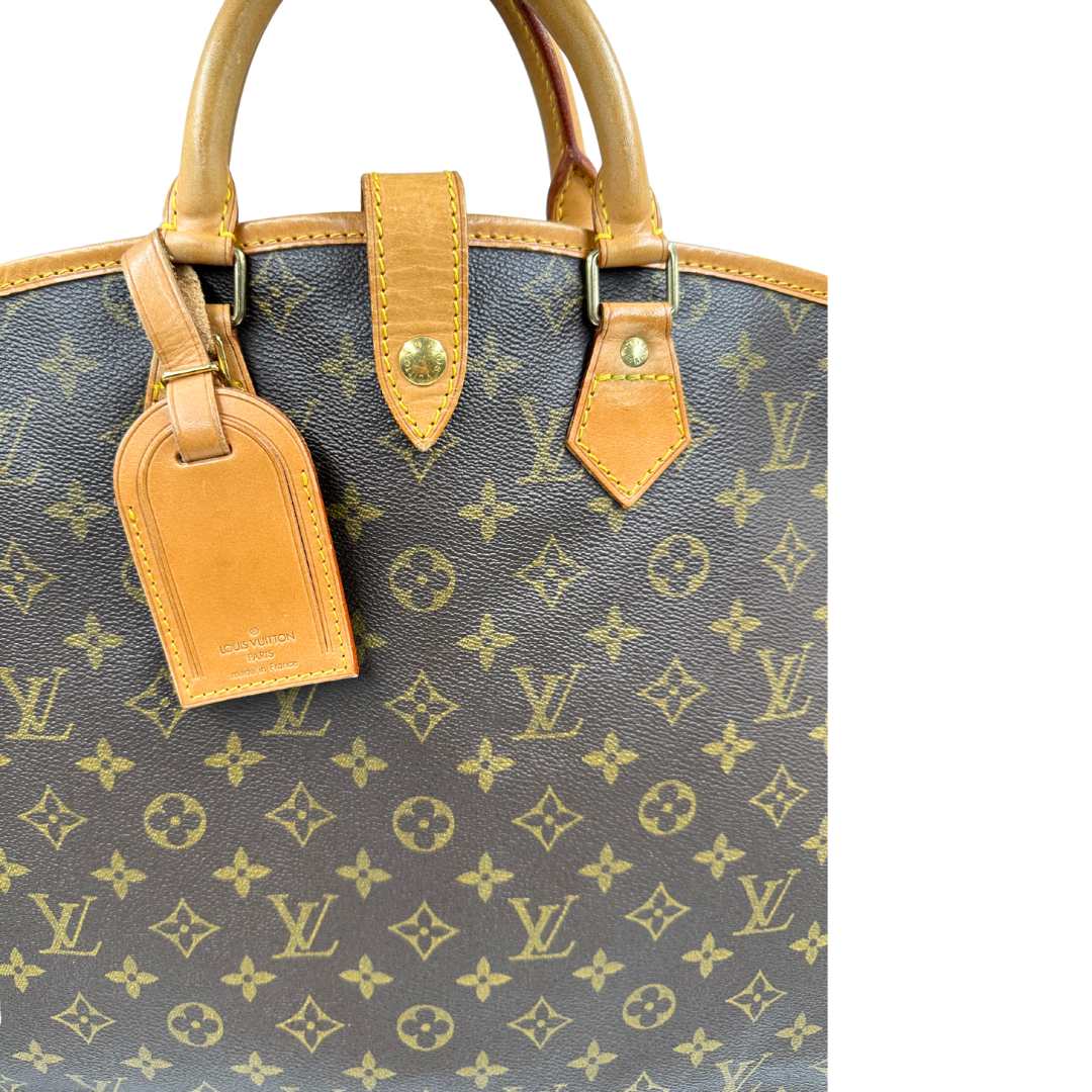 Porta abiti in canvas marrone monogram con finiture in vacchetta naturale e parti metalliche dorate; munita di due manici stondati. Completa di due lucchetto, chiavi, tag porta address e una dustbag. Originale, usata, di lusso, in ottime condizioni.