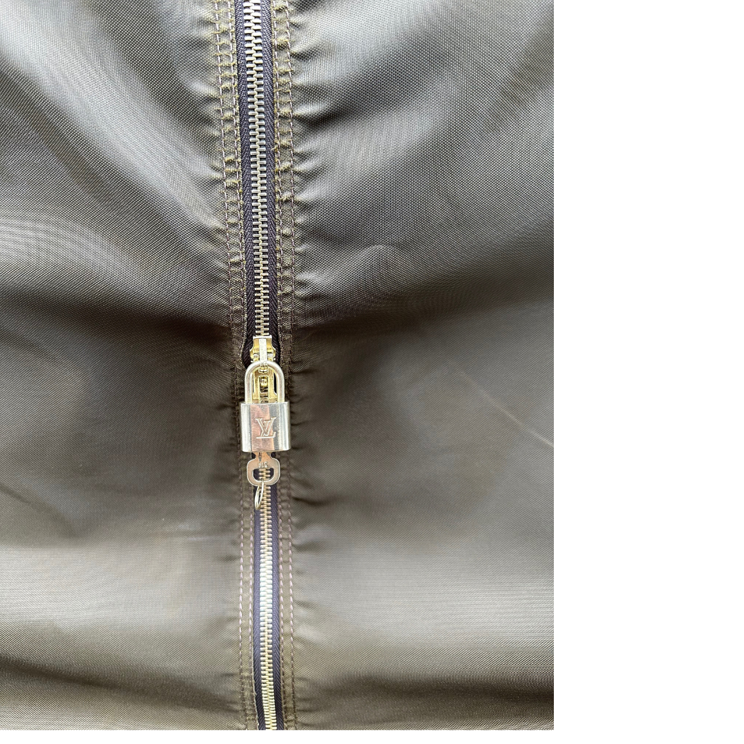 Interno di un Porta abiti in canvas marrone monogram con finiture in vacchetta naturale e parti metalliche dorate; munita di due manici stondati. Completa di due lucchetto, chiavi, tag porta address e una dustbag. Originale, usata, di lusso, in ottime condizioni.