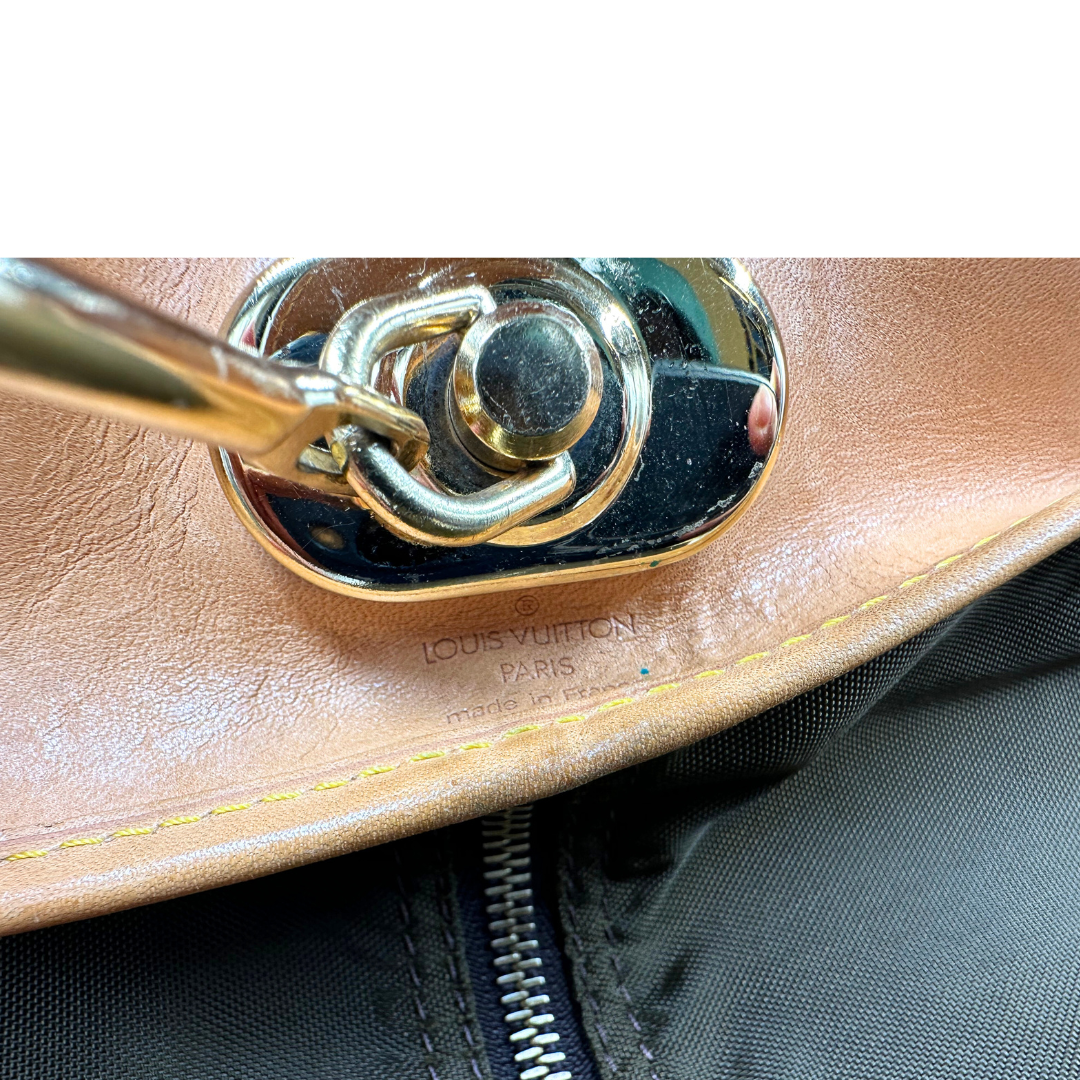 Porta abiti in canvas marrone monogram con finiture in vacchetta naturale e parti metalliche dorate; munita di due manici stondati. Completa di due lucchetto, chiavi, tag porta address e una dustbag. Originale, usata, di lusso, in ottime condizioni.