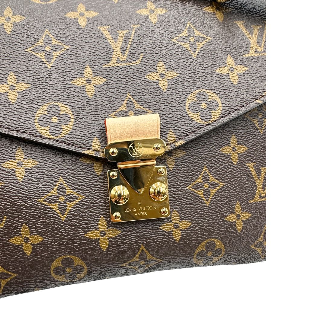 Chiusura di una Borsa Louis Vuitton Métis in canvas marrone monogram con dettagli in vacchetta naturale e parti metalliche dorate. Munita di un manico singolo e una tracolla regolabile e amovibile. Dotata di busta, scatola e dustbag. PRESENZA DI NFC .Originale, usata, di lusso, in ottime condizioni.