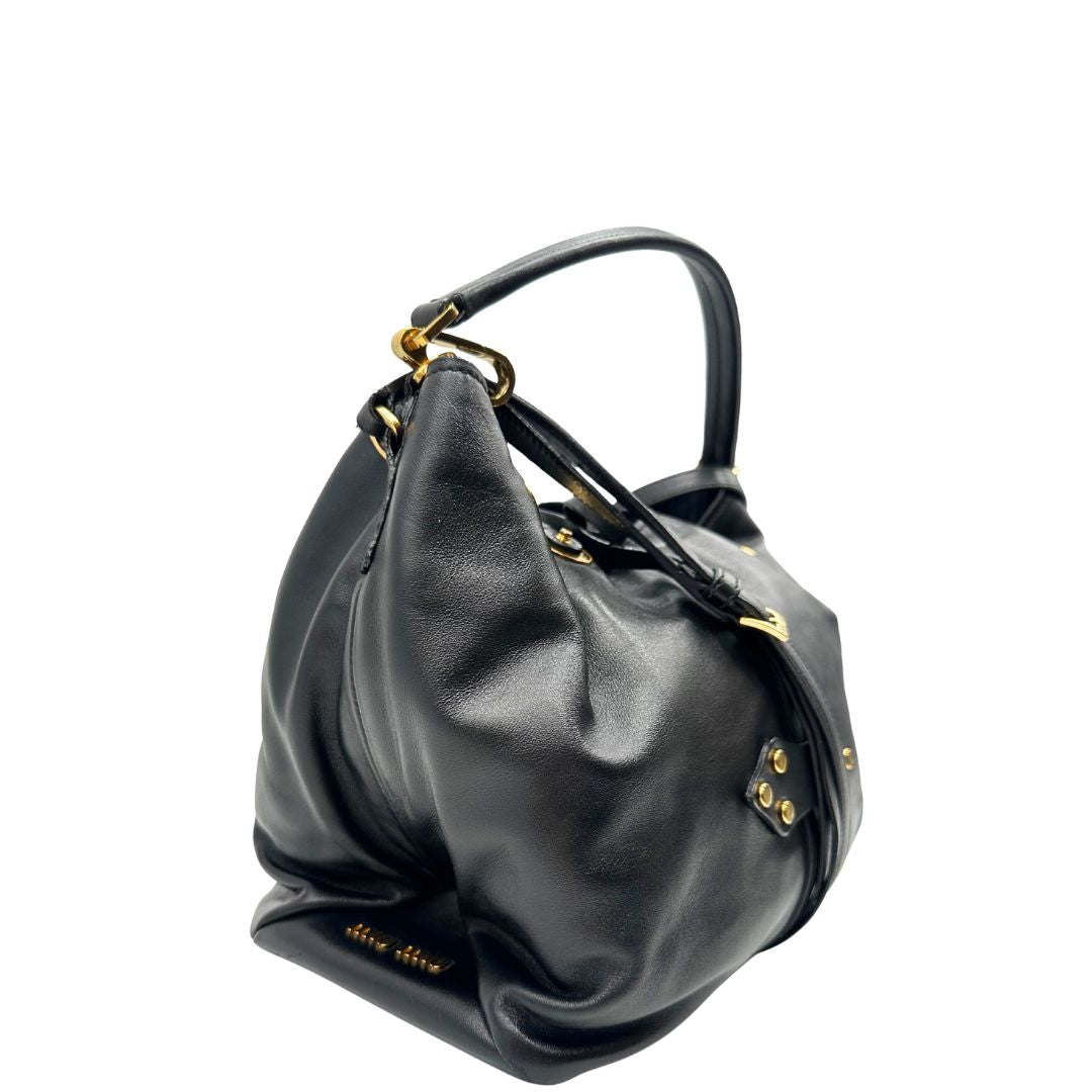 lato Borsa Miu Miu in pelle nera con parti metalliche dorate; munita di un manico singolo e una tracolla amovibile e regolabile. Completa di dustbag, di lusso, originale, ottime condizioni, usata 