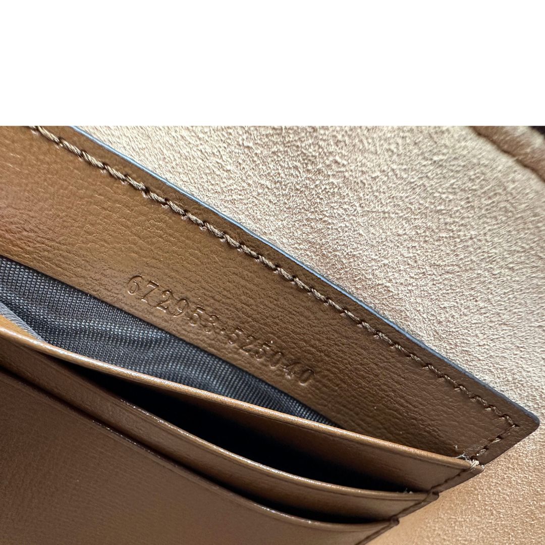 Codice di una Pochette Gucci in canvas GG monogram beige con finiture in pelle marroni e parti metalliche dorate; munita di un polsino in pelle amovibile, indossabile a mano. Originale, usata, di lusso, in ottime condizioni.