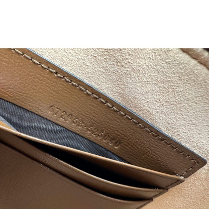 Codice di una Pochette Gucci in canvas GG monogram beige con finiture in pelle marroni e parti metalliche dorate; munita di un polsino in pelle amovibile, indossabile a mano. Originale, usata, di lusso, in ottime condizioni.