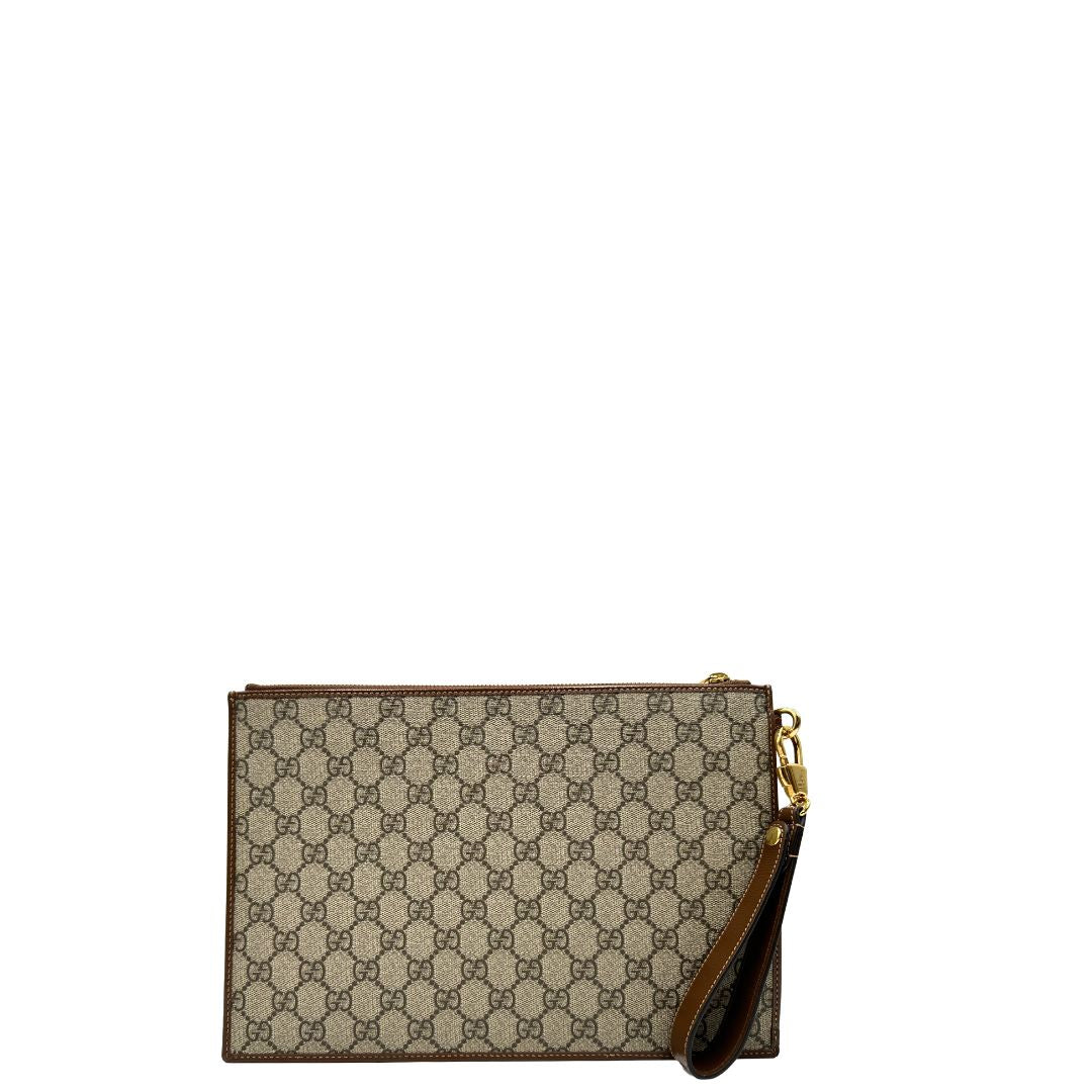 Retro di una Pochette Gucci in canvas GG monogram beige con finiture in pelle marroni e parti metalliche dorate; munita di un polsino in pelle amovibile, indossabile a mano. Originale, usata, di lusso, in ottime condizioni.