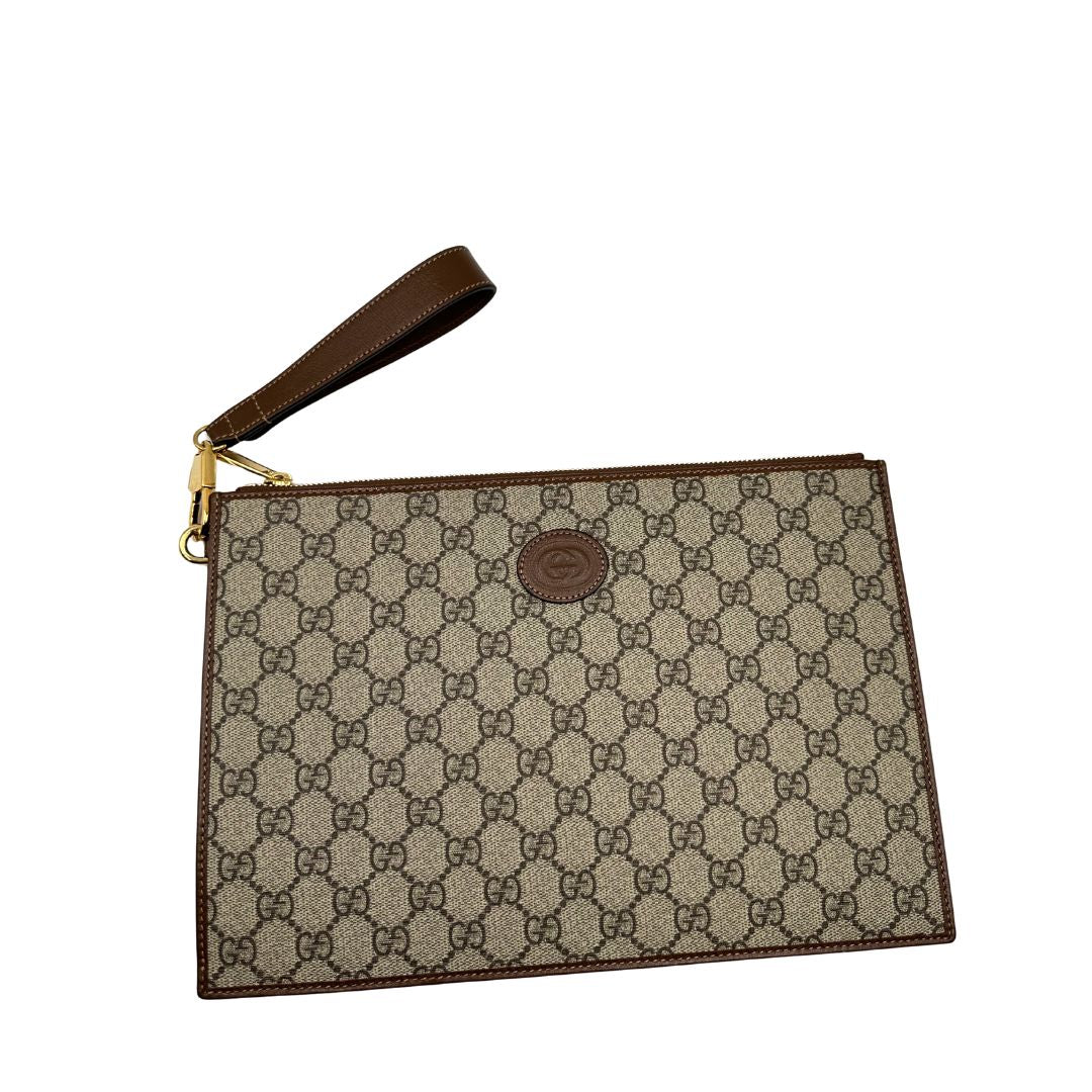 Pochette Gucci in canvas GG monogram beige con finiture in pelle marroni e parti metalliche dorate; munita di un polsino in pelle amovibile, indossabile a mano. Originale, usata, di lusso, in ottime condizioni.