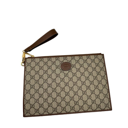 Pochette Gucci in canvas GG monogram beige con finiture in pelle marroni e parti metalliche dorate; munita di un polsino in pelle amovibile, indossabile a mano. Originale, usata, di lusso, in ottime condizioni.
