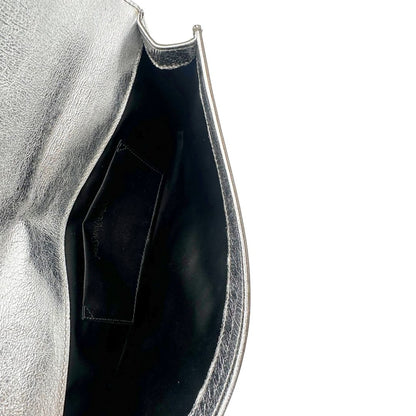 interno Pochette Saint Laurent in pelle argentata effetto invecchiato, impreziosita dal logo Cassandre sul front. Completa di dustbag, di lusso, originale, ottime condizioni, usata. 