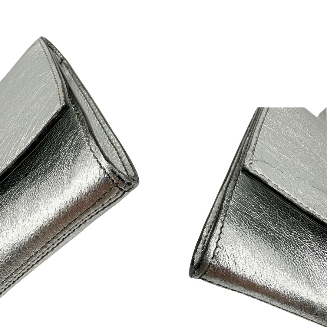 angoli Pochette Saint Laurent in pelle argentata effetto invecchiato, impreziosita dal logo Cassandre sul front. Completa di dustbag, di lusso, originale, ottime condizioni, usata. 