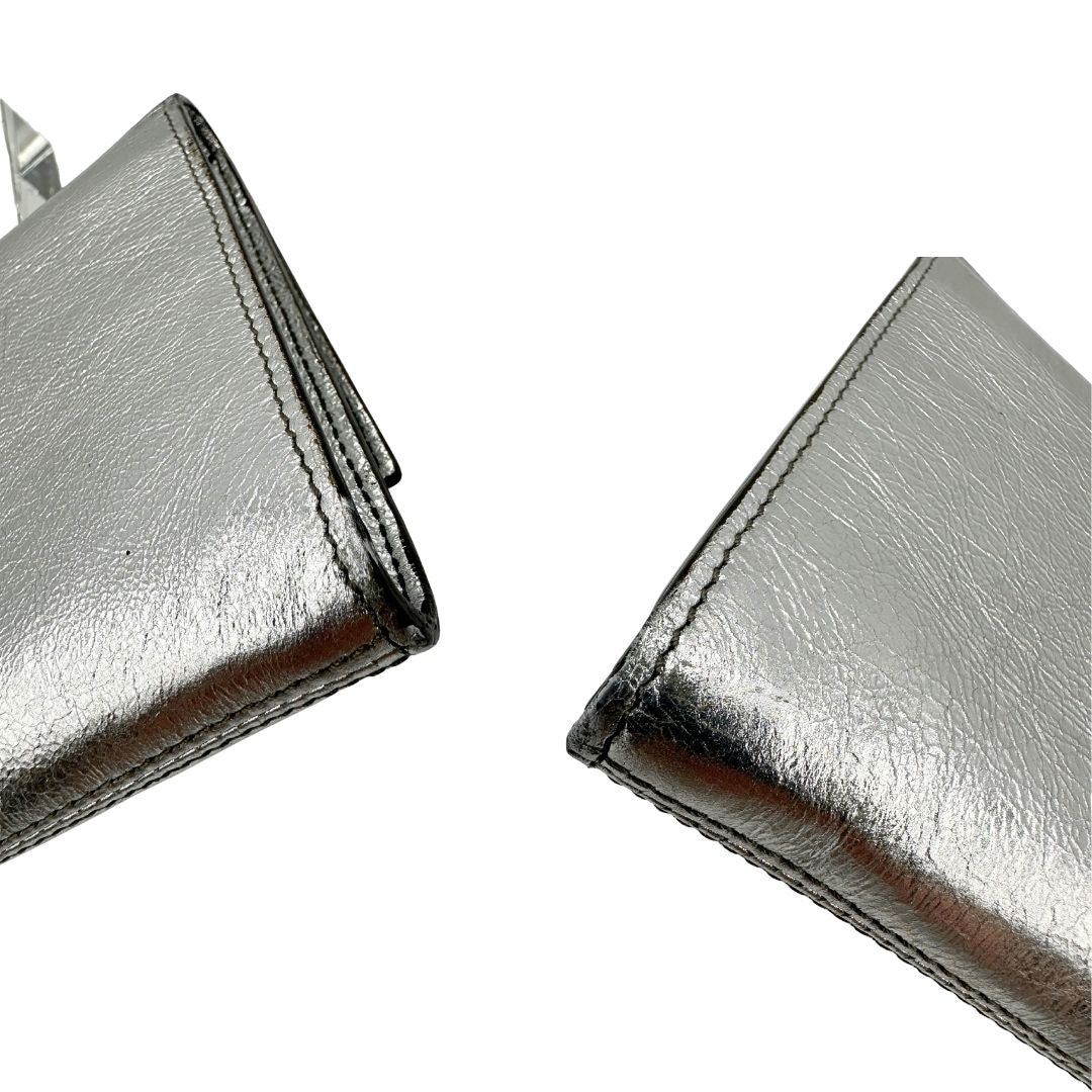 angoli Pochette Saint Laurent in pelle argentata effetto invecchiato, impreziosita dal logo Cassandre sul front. Completa di dustbag, di lusso, originale, ottime condizioni, usata.