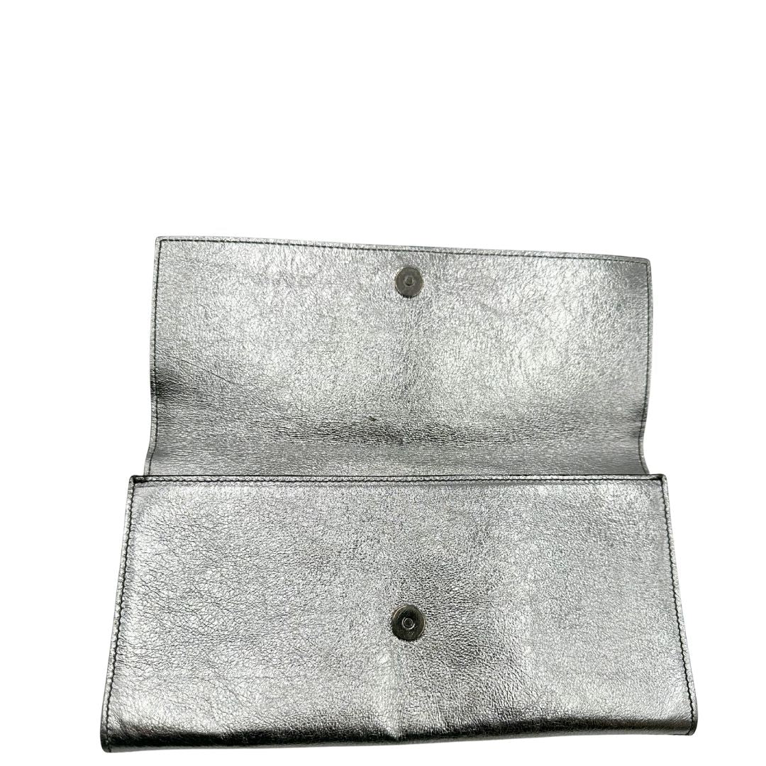 bottone Pochette Saint Laurent in pelle argentata effetto invecchiato, impreziosita dal logo Cassandre sul front. Completa di dustbag, di lusso, originale, ottime condizioni, usata. 