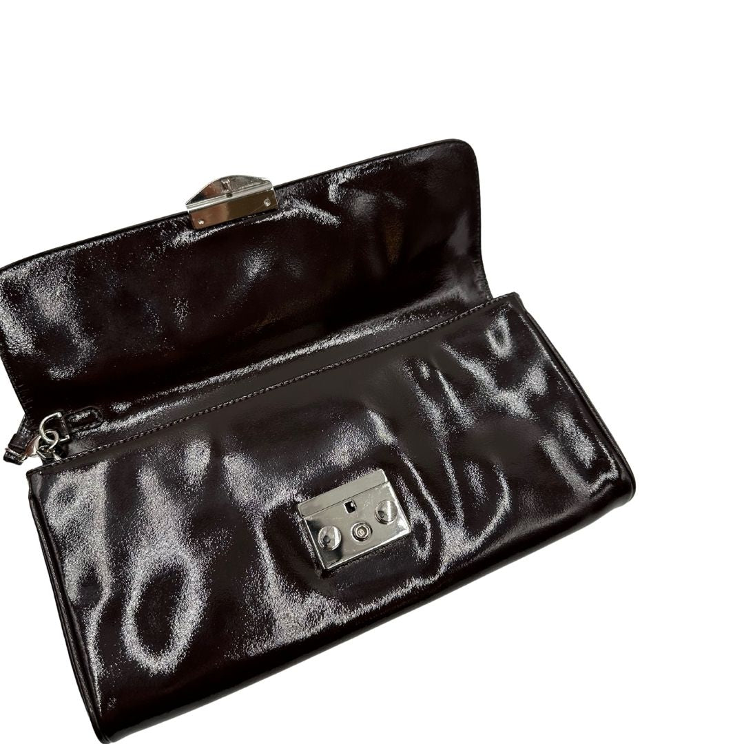 chiusura Pochette Moschino in ecopelle color testa di moro con parti metalliche argentate; munita di un polsino, da portare a mano. Completa di dustbag, di lusso, originale, ottime condizioni, usata. 