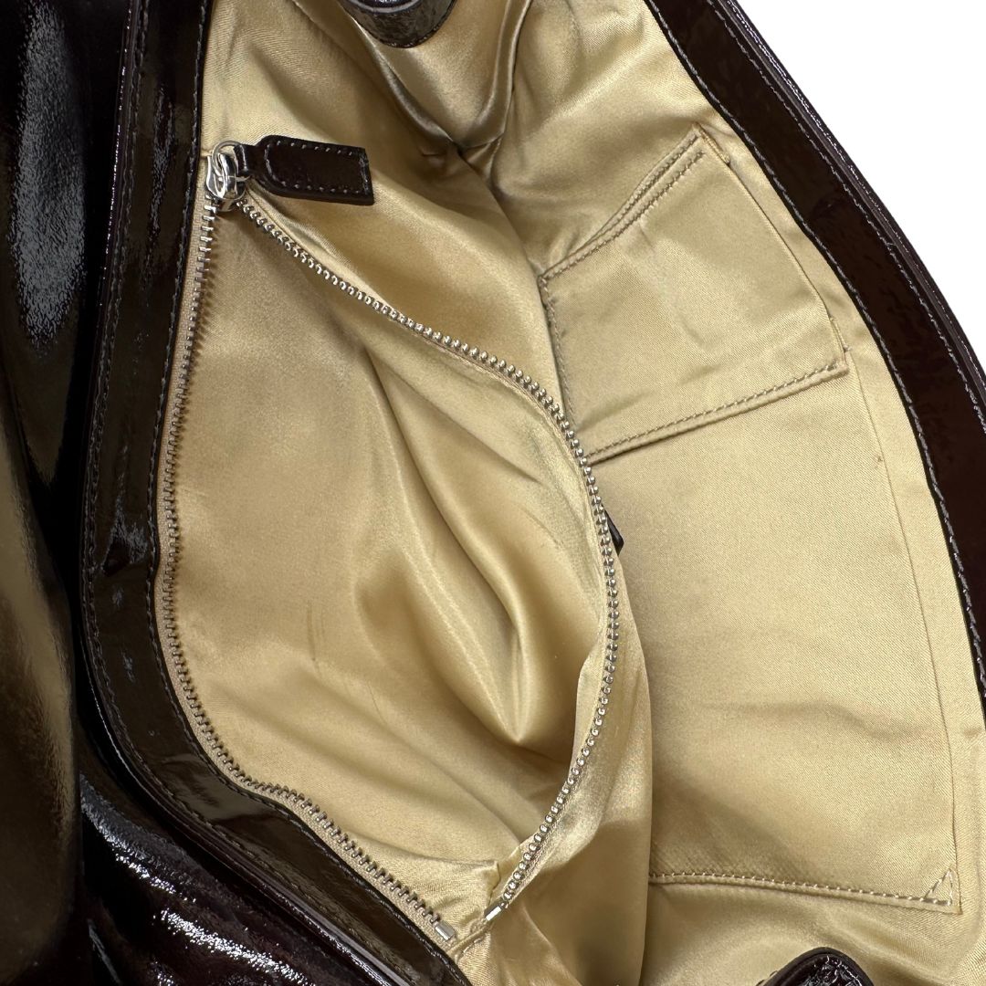 interno Pochette Moschino in ecopelle color testa di moro con parti metalliche argentate; munita di un polsino, da portare a mano. Completa di dustbag, di lusso, originale, ottime condizioni, usata. 