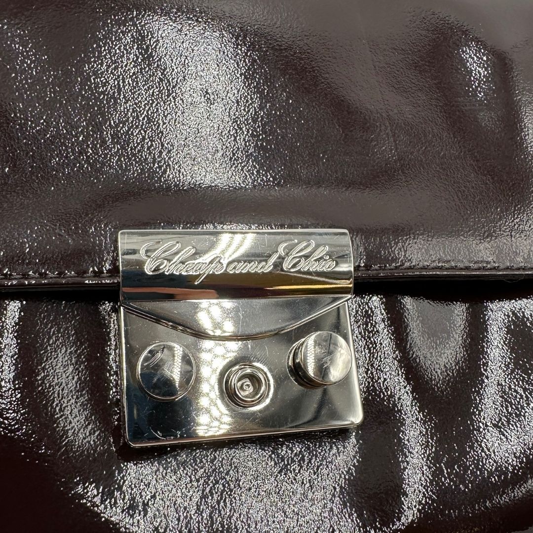 chiusura Pochette Moschino in ecopelle color testa di moro con parti metalliche argentate; munita di un polsino, da portare a mano. Completa di dustbag, di lusso, originale, ottime condizioni, usata. 