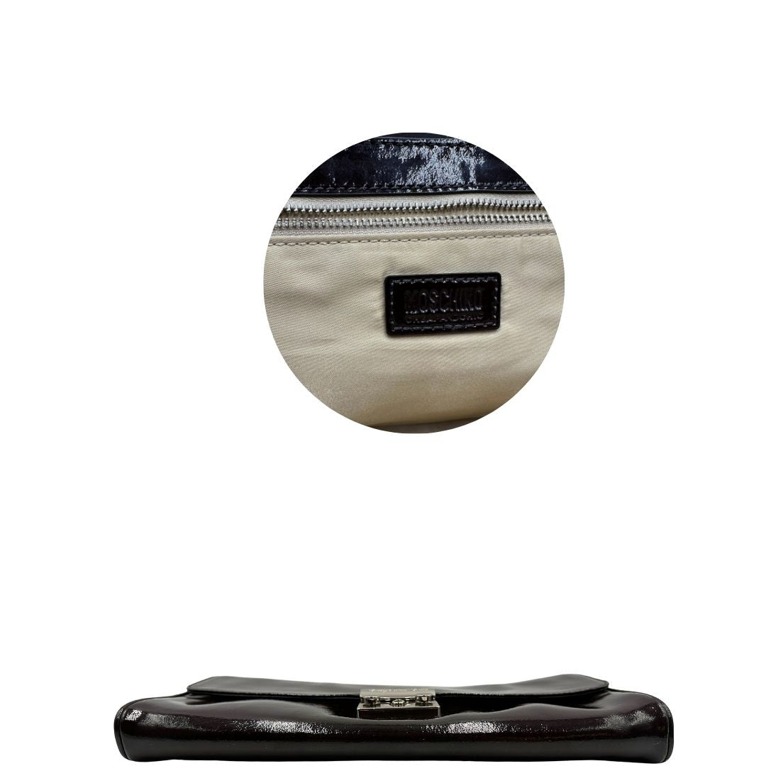 base Pochette Moschino in ecopelle color testa di moro con parti metalliche argentate; munita di un polsino, da portare a mano. Completa di dustbag, di lusso, originale, ottime condizioni, usata.