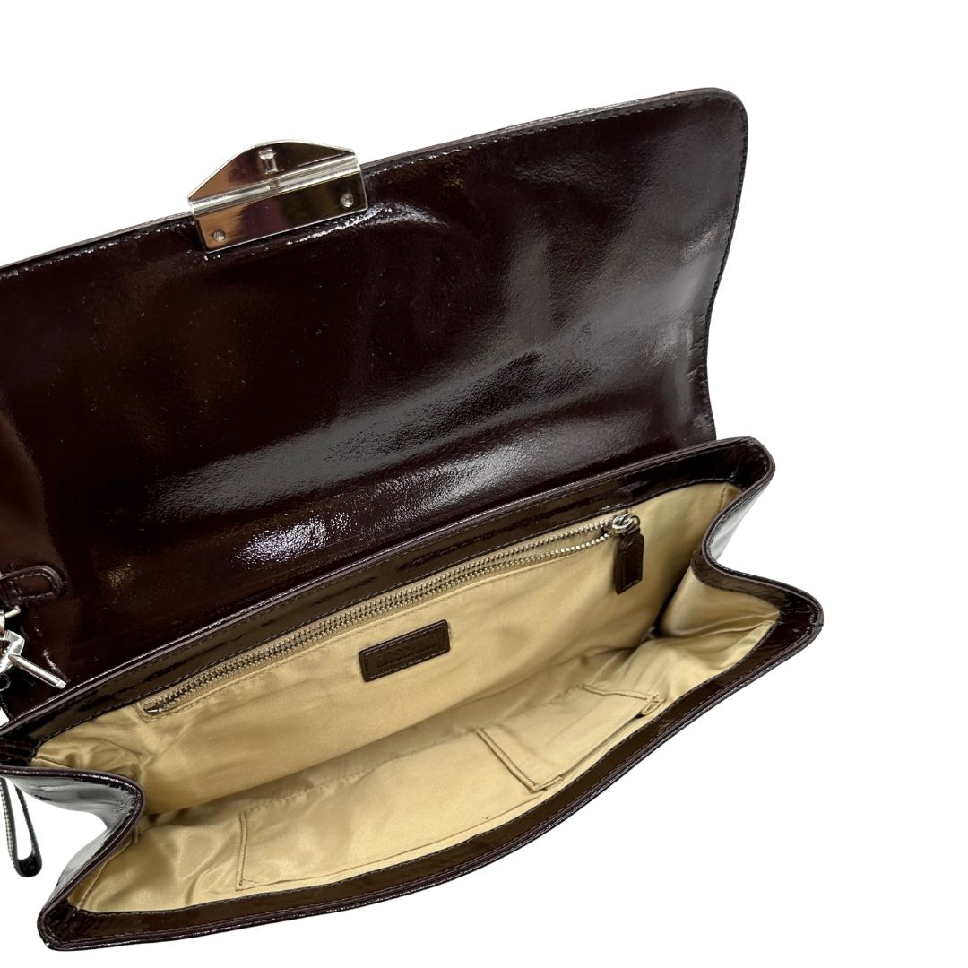 interno Pochette Moschino in ecopelle color testa di moro con parti metalliche argentate; munita di un polsino, da portare a mano. Completa di dustbag, di lusso, originale, ottime condizioni, usata. 