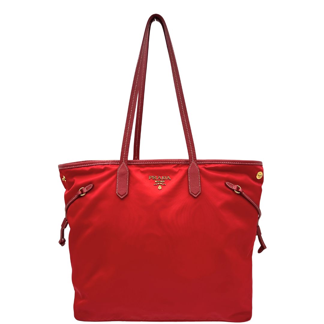 Front di una Borsa Prada in nylon rosso con parti metalliche dorate e finiture in pelle tono su tono, munita di doppi manici, indossabile a spalla. Completa di dustbag. Originale, usata, di lusso, in ottime condizioni.