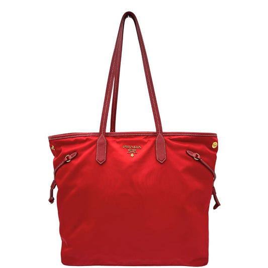 Front di una Borsa Prada in nylon rosso con parti metalliche dorate e finiture in pelle tono su tono, munita di doppi manici, indossabile a spalla. Completa di dustbag. Originale, usata, di lusso, in ottime condizioni.
