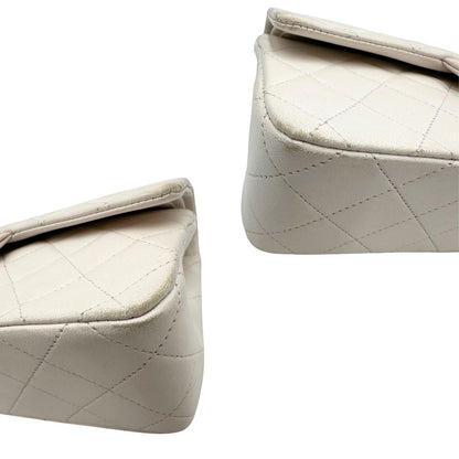 angoli  Borsa Chanel in pelle color bianco gesso e parti metalliche dorate; munita di una tracolla scorrevole in catena con intrecci in pelle bianca, indossabile a spalla o a tracolla. Completa di scatola, di lusso, originale, ottime condizioni, usata.