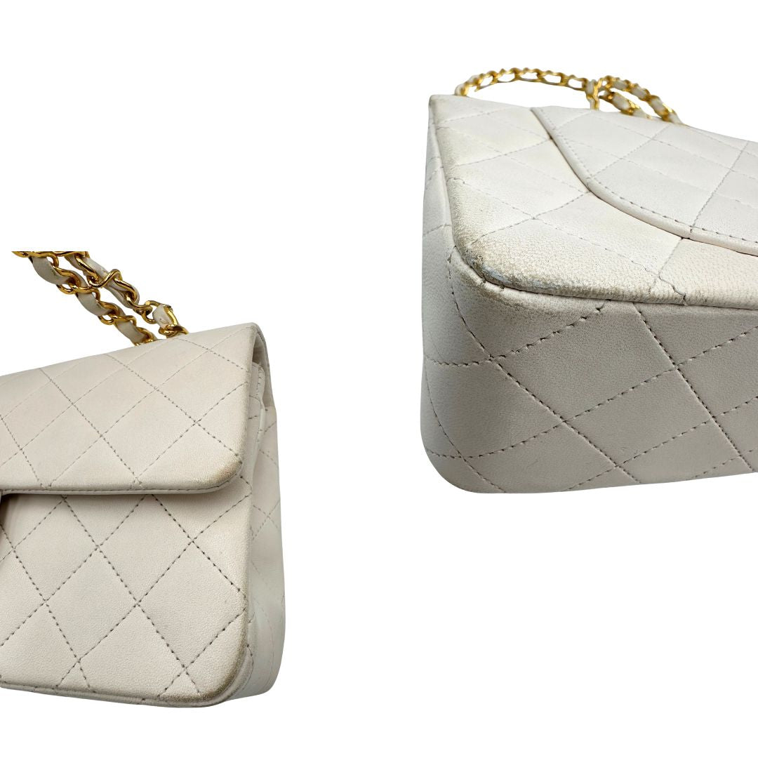 angoli  Borsa Chanel in pelle color bianco gesso e parti metalliche dorate; munita di una tracolla scorrevole in catena con intrecci in pelle bianca, indossabile a spalla o a tracolla. Completa di scatola, di lusso, originale, ottime condizioni, usata. 