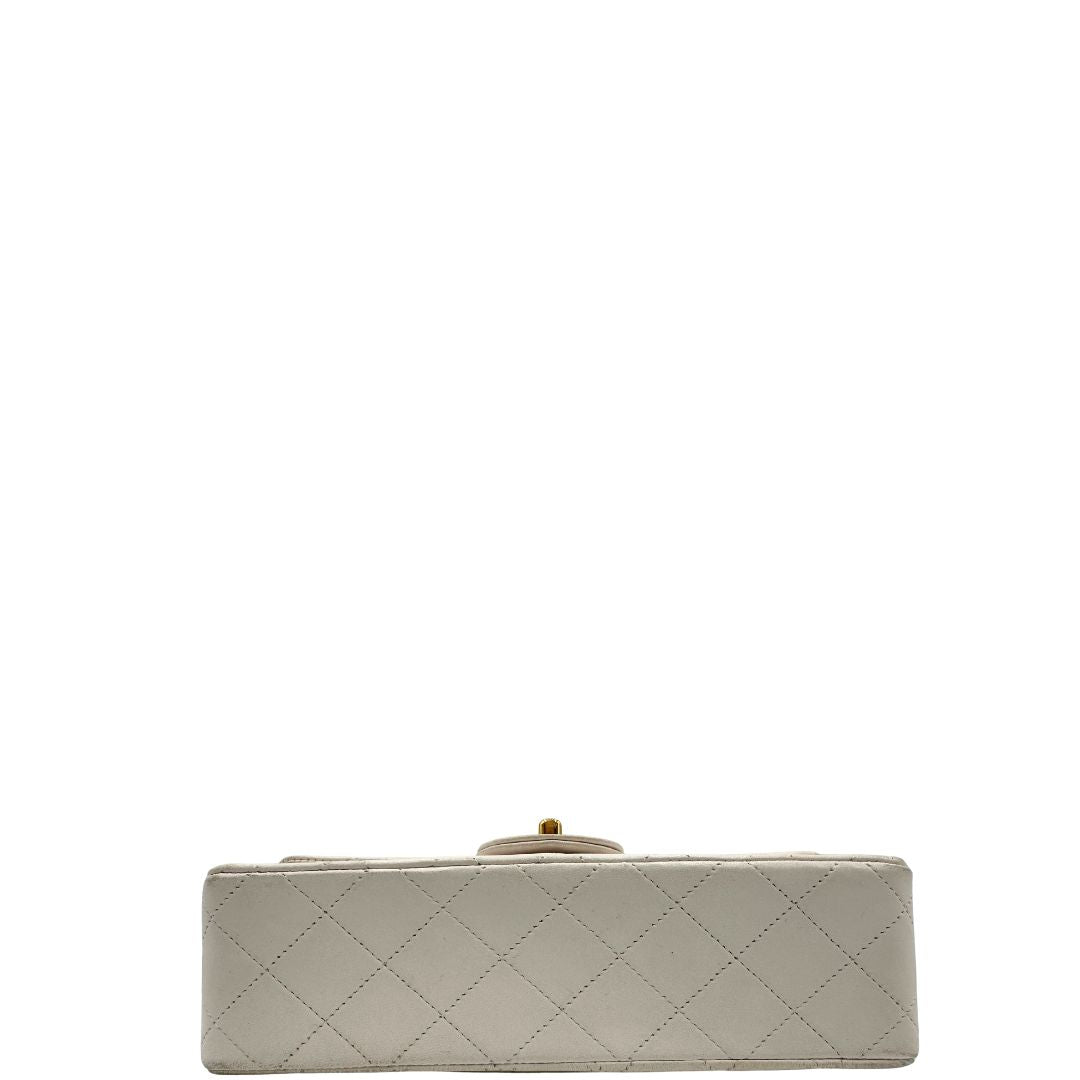 base  Borsa Chanel in pelle color bianco gesso e parti metalliche dorate; munita di una tracolla scorrevole in catena con intrecci in pelle bianca, indossabile a spalla o a tracolla. Completa di scatola, di lusso, originale, ottime condizioni, usata. 