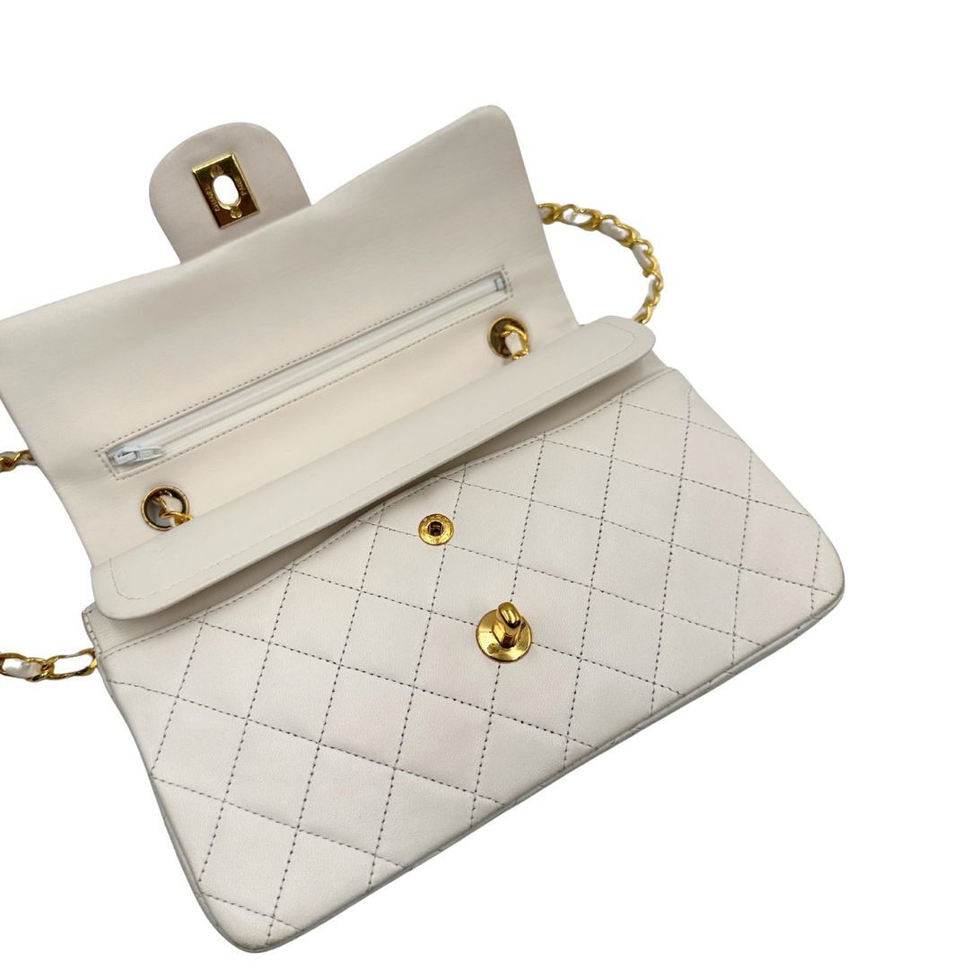  Borsa Chanel in pelle color bianco gesso e parti metalliche dorate; munita di una tracolla scorrevole in catena con intrecci in pelle bianca, indossabile a spalla o a tracolla. Completa di scatola, di lusso, originale, ottime condizioni, usata. 