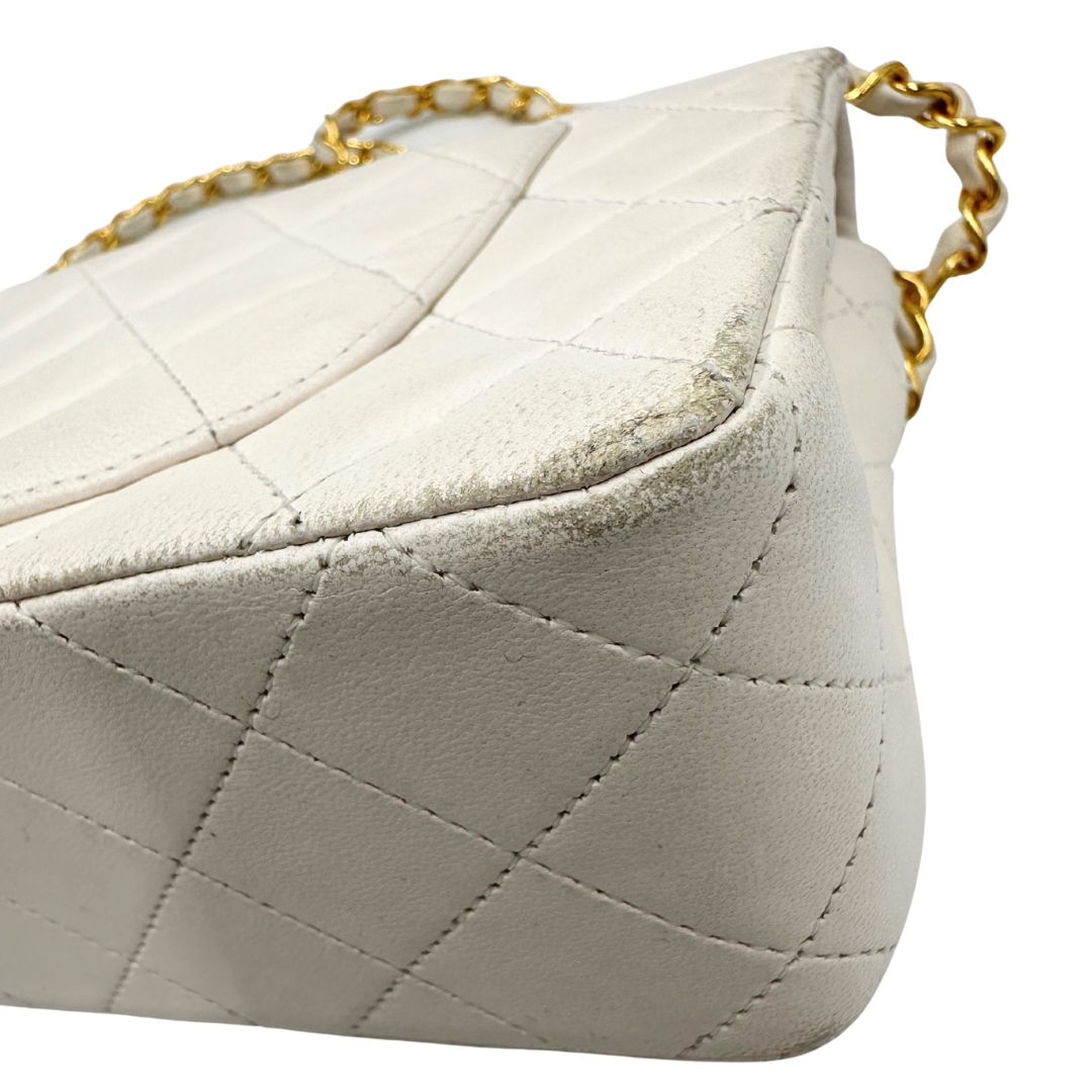 angolo  Borsa Chanel in pelle color bianco gesso e parti metalliche dorate; munita di una tracolla scorrevole in catena con intrecci in pelle bianca, indossabile a spalla o a tracolla. Completa di scatola, di lusso, originale, ottime condizioni, usata. 