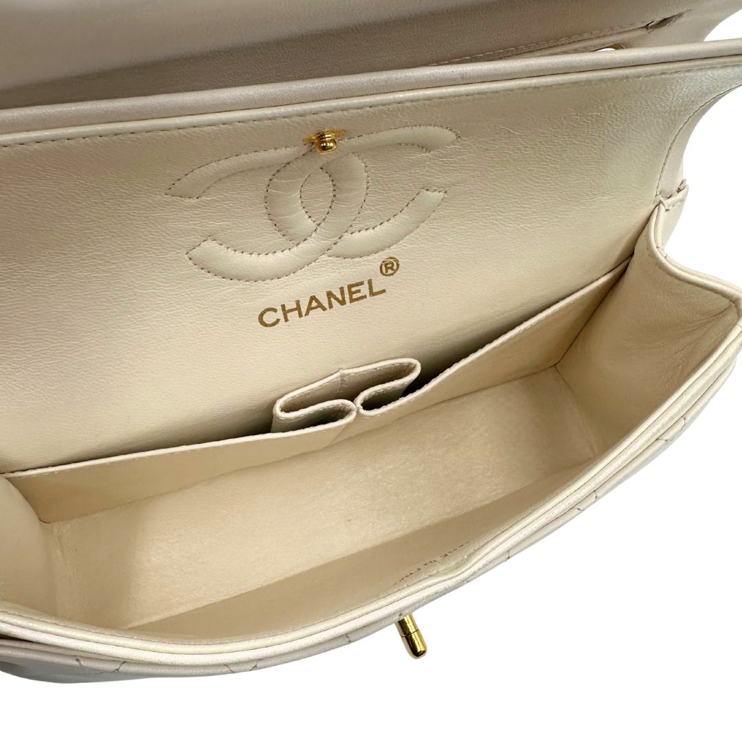 interno  Borsa Chanel in pelle color bianco gesso e parti metalliche dorate; munita di una tracolla scorrevole in catena con intrecci in pelle bianca, indossabile a spalla o a tracolla. Completa di scatola, di lusso, originale, ottime condizioni, usata. 