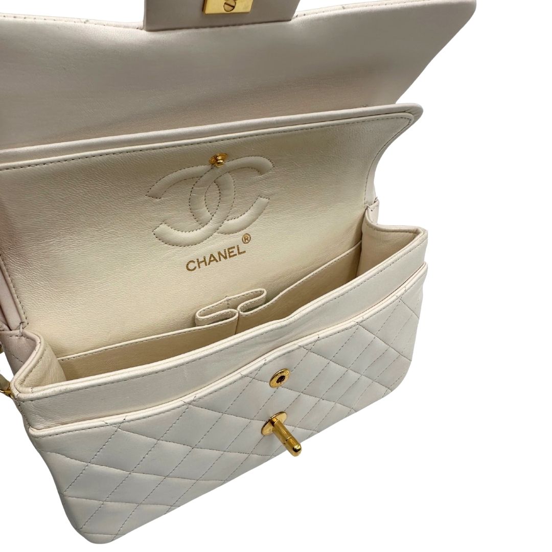  interno Borsa Chanel in pelle color bianco gesso e parti metalliche dorate; munita di una tracolla scorrevole in catena con intrecci in pelle bianca, indossabile a spalla o a tracolla. Completa di scatola, di lusso, originale, ottime condizioni, usata. 