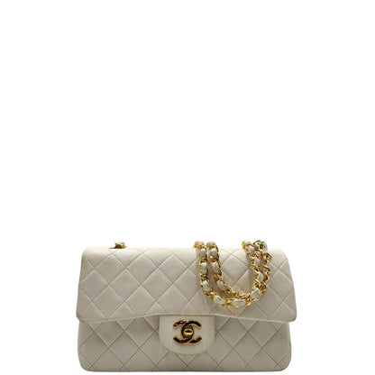 front  Borsa Chanel in pelle color bianco gesso e parti metalliche dorate; munita di una tracolla scorrevole in catena con intrecci in pelle bianca, indossabile a spalla o a tracolla. Completa di scatola, di lusso, originale, ottime condizioni, usata. 
