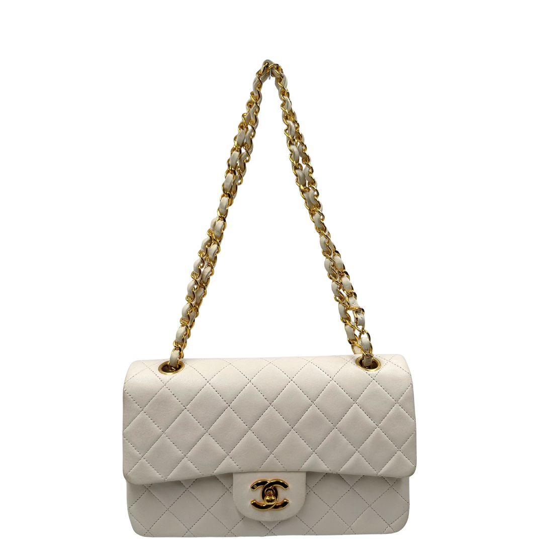 front  Borsa Chanel in pelle color bianco gesso e parti metalliche dorate; munita di una tracolla scorrevole in catena con intrecci in pelle bianca, indossabile a spalla o a tracolla. Completa di scatola, di lusso, originale, ottime condizioni, usata. 