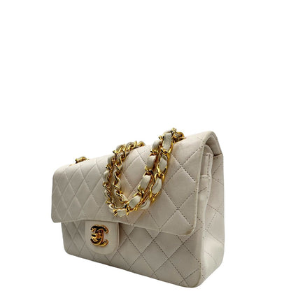 lato  Borsa Chanel in pelle color bianco gesso e parti metalliche dorate; munita di una tracolla scorrevole in catena con intrecci in pelle bianca, indossabile a spalla o a tracolla. Completa di scatola, di lusso, originale, ottime condizioni, usata. 