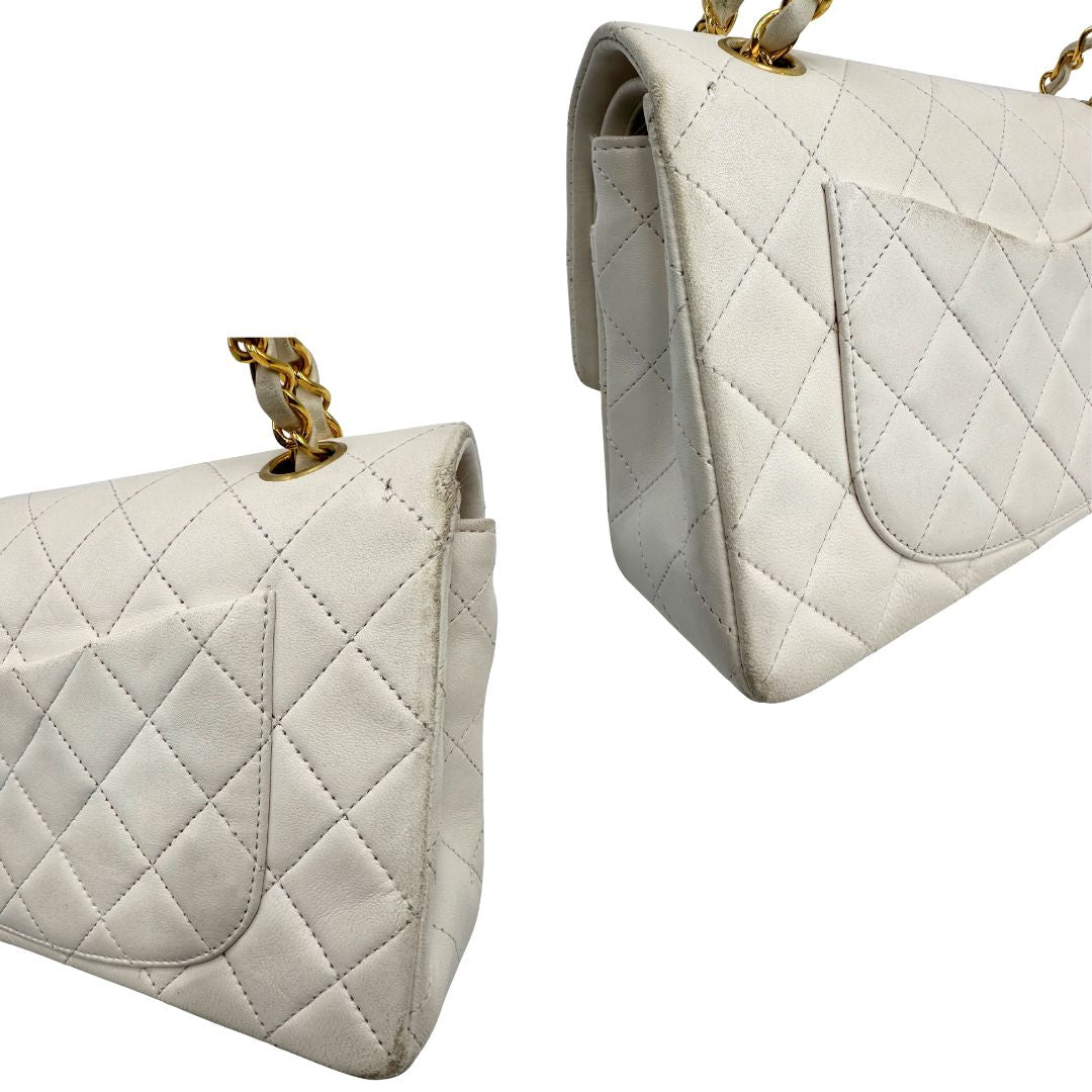 angoli  Borsa Chanel in pelle color bianco gesso e parti metalliche dorate; munita di una tracolla scorrevole in catena con intrecci in pelle bianca, indossabile a spalla o a tracolla. Completa di scatola, di lusso, originale, ottime condizioni, usata. 