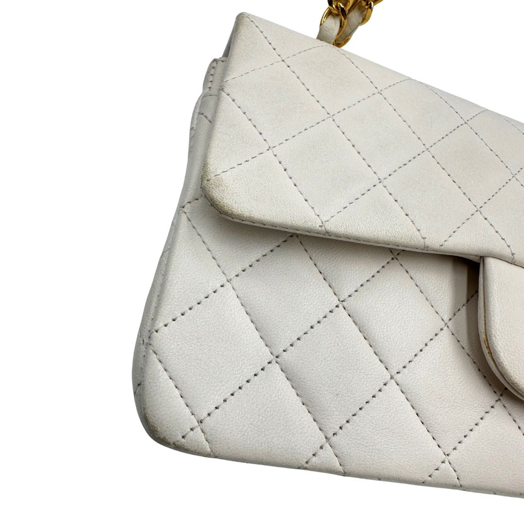  Borsa Chanel in pelle color bianco gesso e parti metalliche dorate; munita di una tracolla scorrevole in catena con intrecci in pelle bianca, indossabile a spalla o a tracolla. Completa di scatola, di lusso, originale, ottime condizioni, usata. 