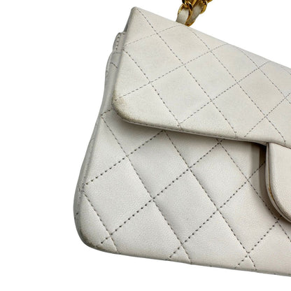  Borsa Chanel in pelle color bianco gesso e parti metalliche dorate; munita di una tracolla scorrevole in catena con intrecci in pelle bianca, indossabile a spalla o a tracolla. Completa di scatola, di lusso, originale, ottime condizioni, usata. 