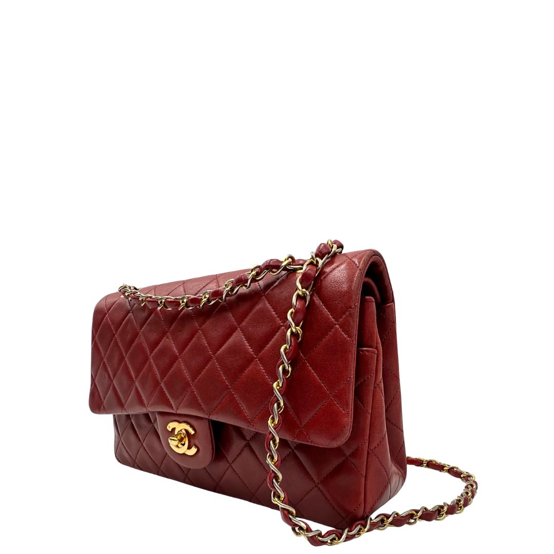 Lato sinistro di una Borsa Chanel in pelle color terra di siena bruciata matelassè con parti metalliche dorate; munita di una tracolla scorrevole in catena e pelle. Indossabile a spalla e a tracolla. Completa di scatola e Dustbag. Originale, usata, di lusso, in ottime condizioni.