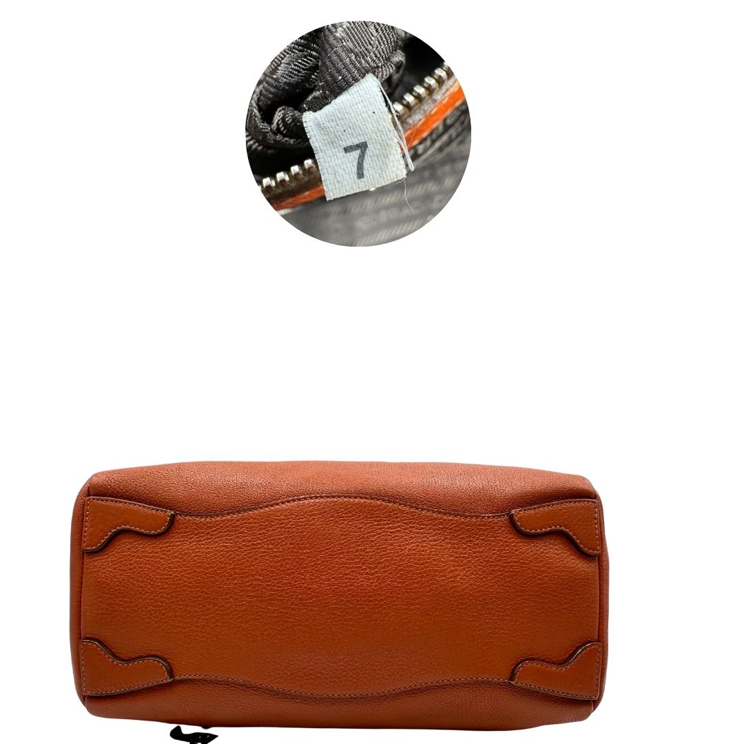 base  Borsa Prada in pelle martellata color cognac con parti metalliche argentate; munita di doppi manici, indossabile a spalla. Completa di lucchetto e chiavi, di lusso, originale, ottime condizioni, usata. 