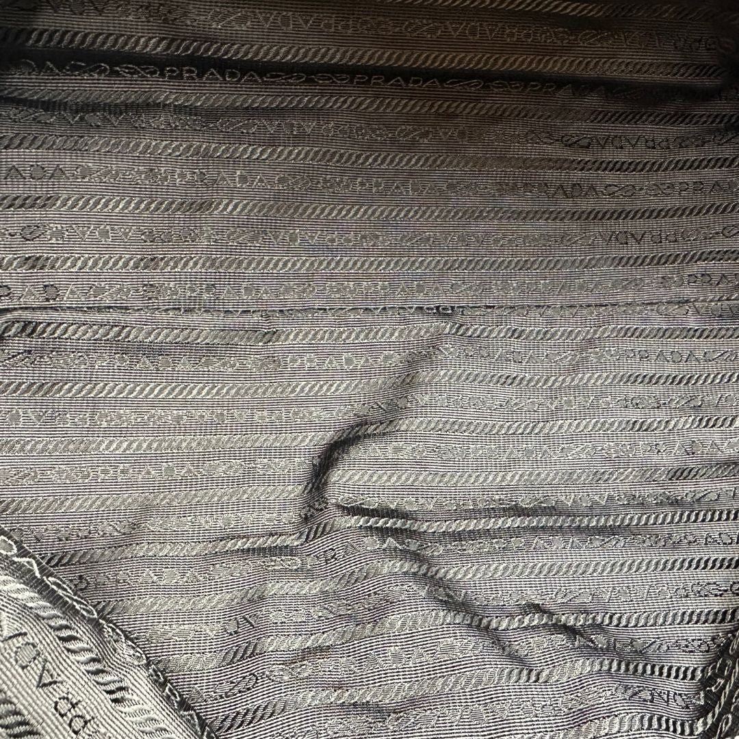 interno  Borsa Prada in pelle martellata color cognac con parti metalliche argentate; munita di doppi manici, indossabile a spalla. Completa di lucchetto e chiavi, di lusso, originale, ottime condizioni, usata. 