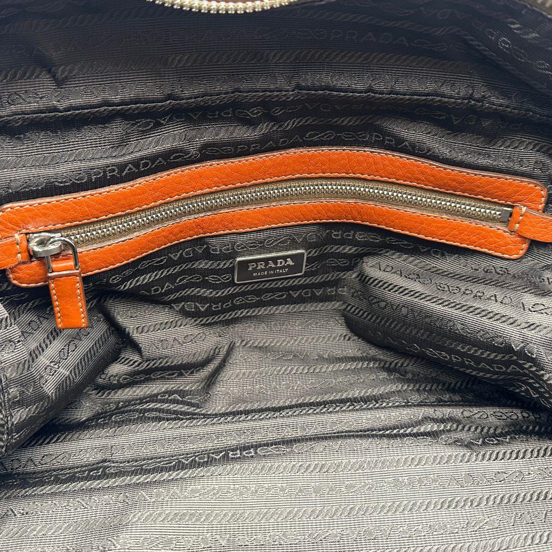 interno  Borsa Prada in pelle martellata color cognac con parti metalliche argentate; munita di doppi manici, indossabile a spalla. Completa di lucchetto e chiavi, di lusso, originale, ottime condizioni, usata. 