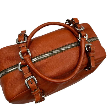 manici  Borsa Prada in pelle martellata color cognac con parti metalliche argentate; munita di doppi manici, indossabile a spalla. Completa di lucchetto e chiavi, di lusso, originale, ottime condizioni, usata. 