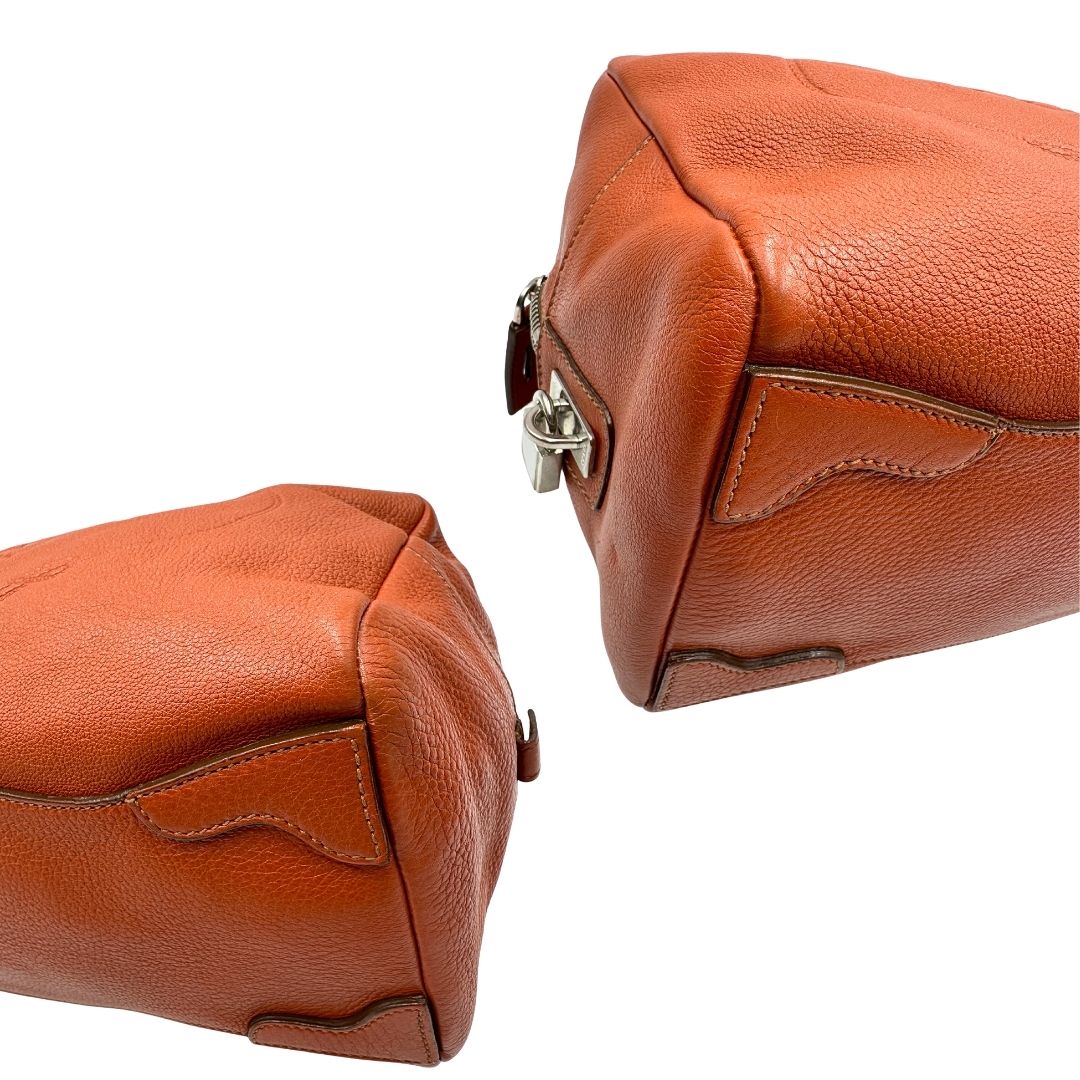 angoli  Borsa Prada in pelle martellata color cognac con parti metalliche argentate; munita di doppi manici, indossabile a spalla. Completa di lucchetto e chiavi, di lusso, originale, ottime condizioni, usata. 