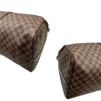 angoli Borsone Louis Vuitton in canvas Damier Ébène marrone con finiture in pelle tono su tono e parti metalliche dorate; munito di doppi manici stondati e una tracolla amovibile e regolabile. Completo di lucchetto, chiavi e dustbag, di lusso, originale, ottime condizioni, usato. 