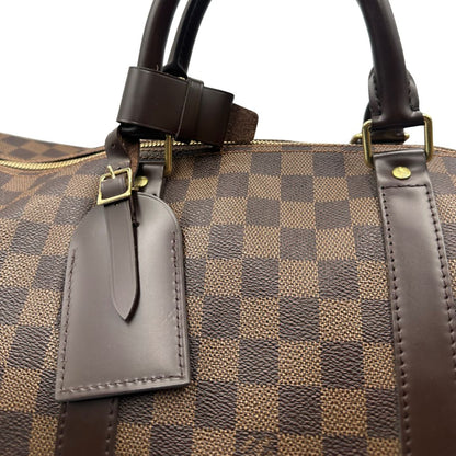 Borsone Louis Vuitton in canvas Damier Ébène marrone con finiture in pelle tono su tono e parti metalliche dorate; munito di doppi manici stondati e una tracolla amovibile e regolabile. Completo di lucchetto, chiavi e dustbag, di lusso, originale, ottime condizioni, usato. 