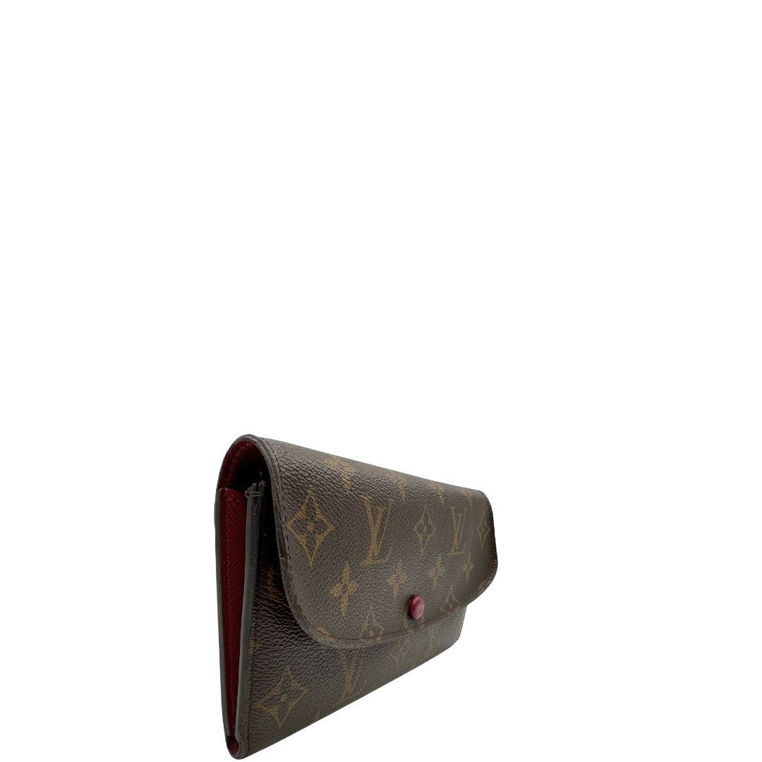 Lato destro di un Portafoglio Louis Vuitton Sarah in canvas monogrammato marrone e parti metalliche dorate con bottoncino amaranto. Completo di scatola. Originale, usata, di lusso, in ottime condizioni.