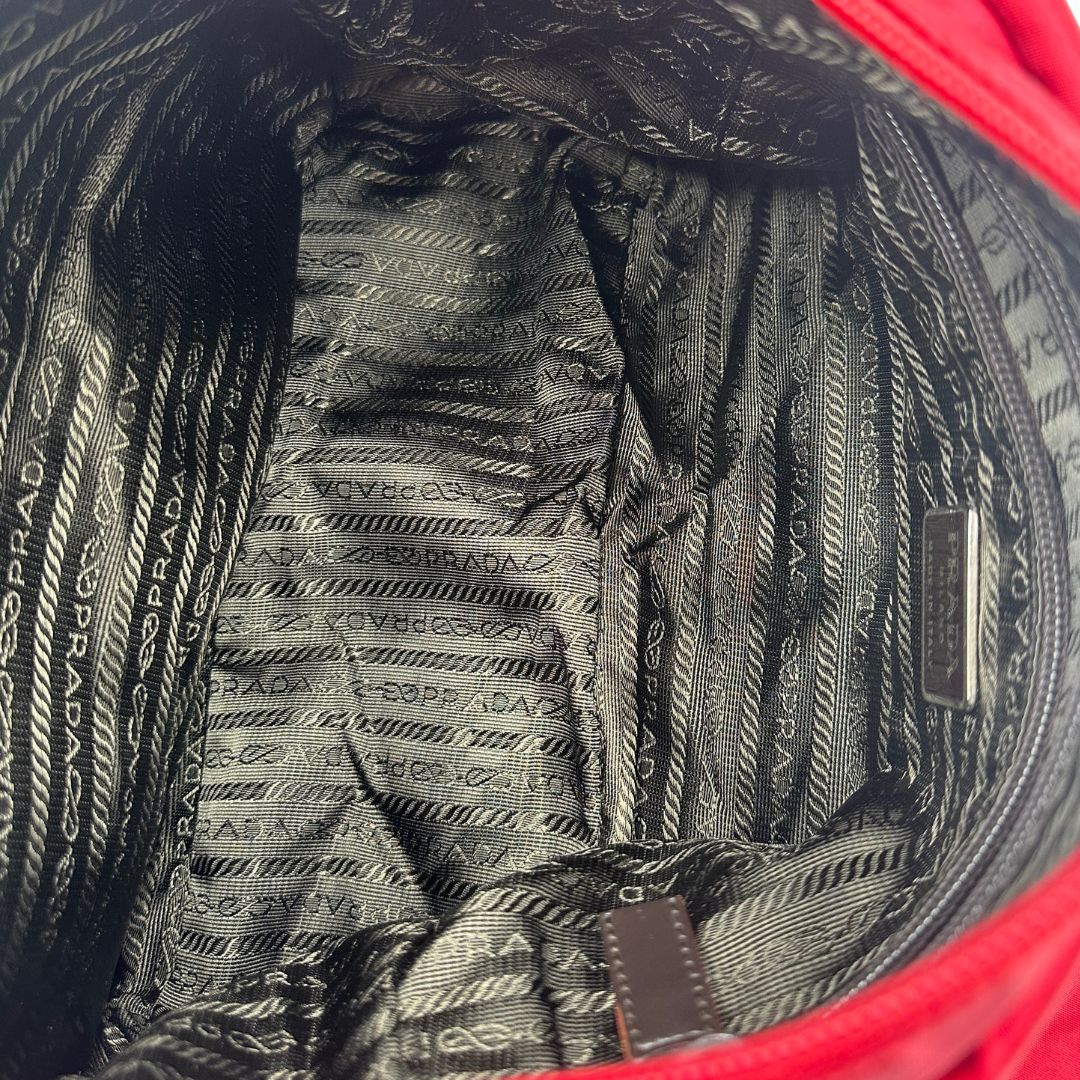 interno Borsa Prada in nylon rosso con finiture in pelle tono su tono e parti metalliche argentate; munita di una tracolla regolabile in tessuto. Completa di dustbag,di lusso, originale, ottime condizioni, usata. 