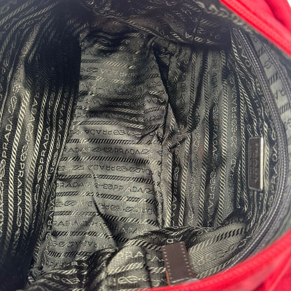 interno Borsa Prada in nylon rosso con finiture in pelle tono su tono e parti metalliche argentate; munita di una tracolla regolabile in tessuto. Completa di dustbag,di lusso, originale, ottime condizioni, usata. 