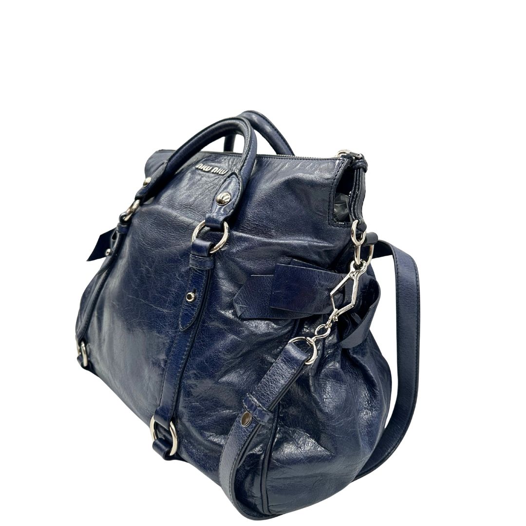 lato Borsa Miu Miu in pelle blu con parti metalliche argentate; munita di doppi manici e una tracolla amovibile. Completa di dustbag, di lusso, originale, ottime condizioni, usata, originale. 