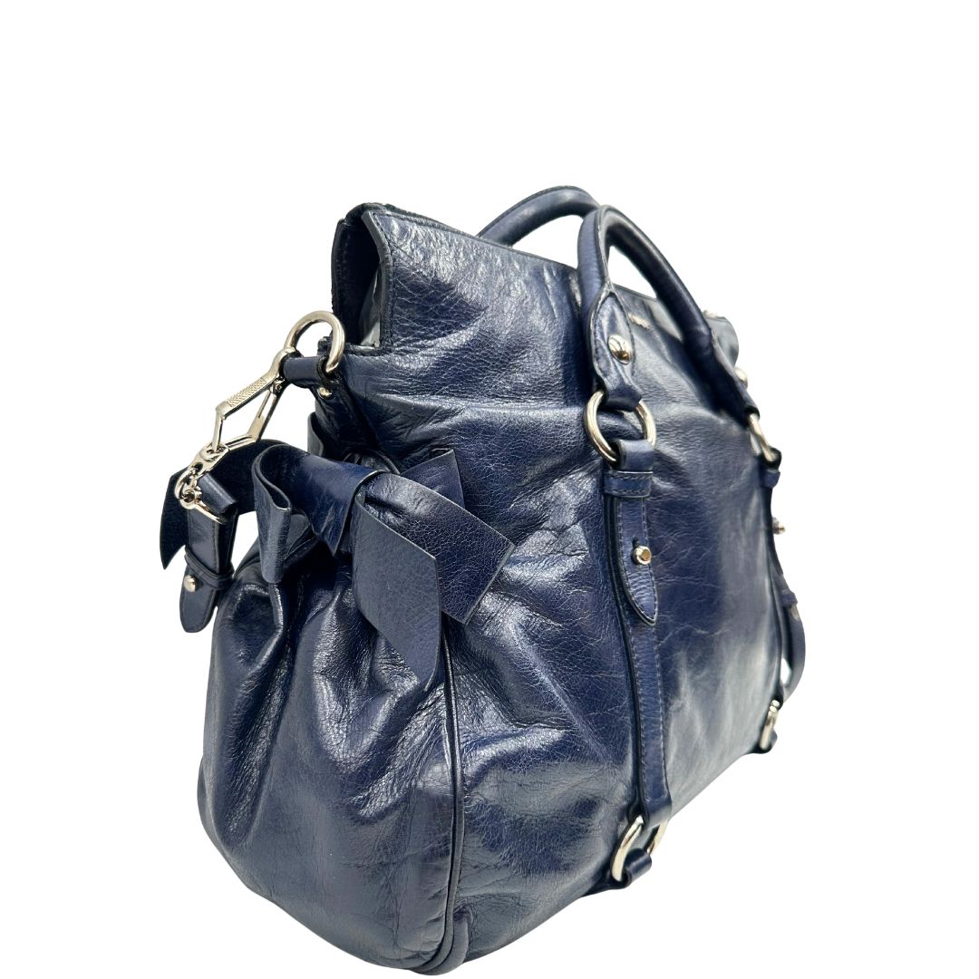 lato Borsa Miu Miu in pelle blu con parti metalliche argentate; munita di doppi manici e una tracolla amovibile. Completa di dustbag, di lusso, originale, ottime condizioni, usata, originale. 